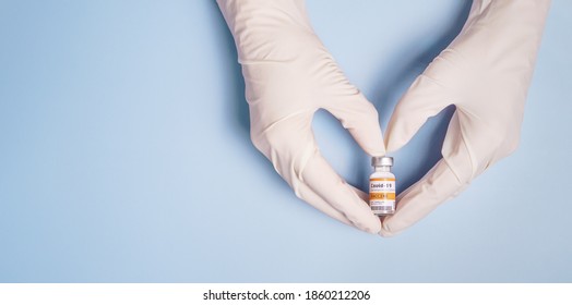 Doctor's Hands in medical latex gloves holding Coronavirus 2019-nCoV Vaccine vial and gesture in heart shape. Successful, Hope, Good news, Support, Donation, Priority, Fight with Covid-19 pandemic. - Shutterstock ID 1860212206