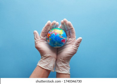 Doctor's Hands In Medical Surgical Gloves Holding Earth Globe On Blue Background, World Health Day And Global Health Care Concept