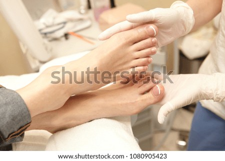 doctor's hands restore damaged nails on the female leg