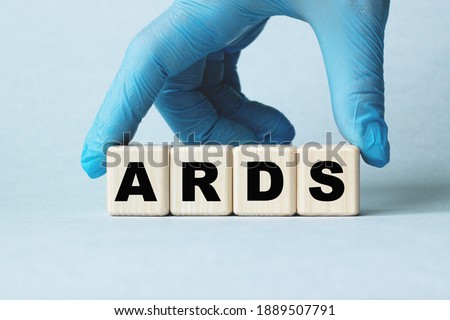 The doctor's hands show the word ARDS . a gloved hand on a white background. Medical concept. the medicine