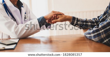 Doctors hold hands to comfort and encourage cancer patients. The concept of psychiatric treatment.