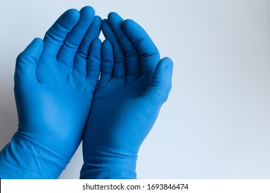 Doctors Male Hands In Nitrile Blue Medical Gloves Holding His Palms Up Like Holding Something.  
Closeup On Isolated White Background. 