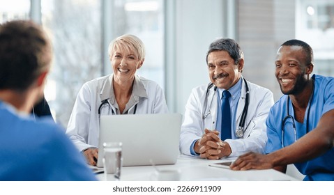 Doctors, medical professionals and healthcare workers with laptop talking, meeting or planning medicine treatment in hospital. Diverse group of happy frontline colleagues researching or brainstorming - Powered by Shutterstock