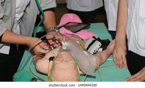 Doctors And Medical Student Give Resuscitation To A Simulation Patients In The Emergency Room. Cardiac Massage. Defibrillation
