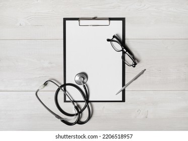 Doctor's medical supplies. Blank clipboard, stethoscope, glasses and pen. Flat lay. - Powered by Shutterstock