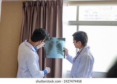 Doctors of the medical team describe the x-ray film of the pulmonary illness of the elderly, the atmosphere in the patient room in the clinic - Powered by Shutterstock