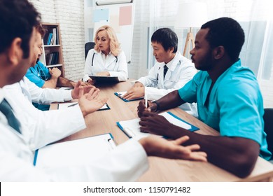 Doctors Meeting. Diagnostic Discussion. Multinational Medicals. Professional Consultation. Patient's Test Results. Young Specialists. Clinician Team Group. Physician Assistants. Sitting Interns.