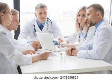 Doctors meeting at a large white table - Powered by Shutterstock