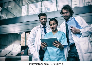 Doctors and nurse looking at digital tablet in hospital