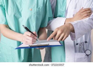 Doctor's And Nurse's Hand And Patient Chart