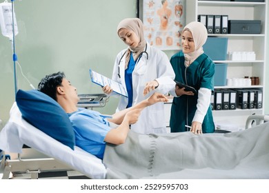 Doctors and nurses in hijabs offering care to a patient in a hospital ward, showcasing teamwork, professionalism, and a compassionate healthcare environment. - Powered by Shutterstock