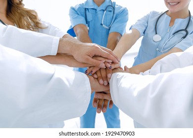 Ärzte und Krankenschwestern in einem medizinischen Team, das Hände stapelt