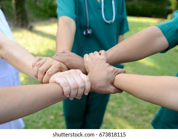 Doctors And Nurses In A Medical Team Stacking Hands Outdoor On The Green Park Background (volunteer)