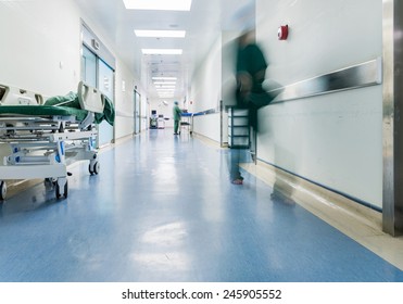 Doctors and nurses walking in hospital hallway, blurred motion. 