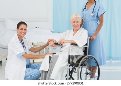 Doctors And Patient In Wheelchair At The Hospital