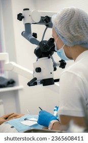 Doctors and patients in dentistry. Dental treatment in dentistry. Dentist treats teeth using a microscope. - Shutterstock ID 2365608411