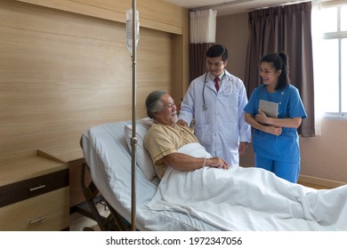 Doctors And Physical Therapists Are Caring For Elderly Sick People. Doctor And Nurse Taking Care Of Elderly Patient On The Bed At Hospital Room.