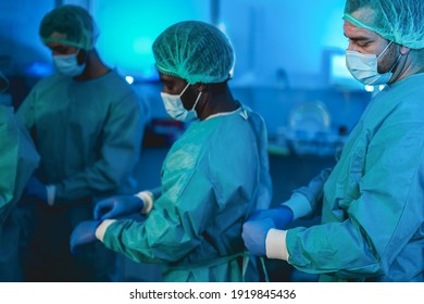 Doctors preparing to work in hospital during coronavirus pandemic outbreak - Focus on right man face - Shutterstock ID 1919845436