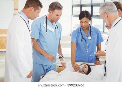 Doctors Putting An Oxygen Mask On Patient In Hospital