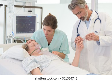 Doctors Putting An Oxygen Mask On Patient In Hospital