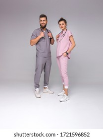 doctors relationship. male and female nurses in medical costumes with stethoscope on neck are standing fashion with smiles on the gray wall background, lifestyle medical concept, free space