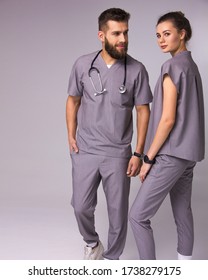 doctors relationship. male and female nurses in medical costumes with stethoscope on neck are standing like team with smiles on the gray wall background, lifestyle medical concept, free space - Shutterstock ID 1738279175