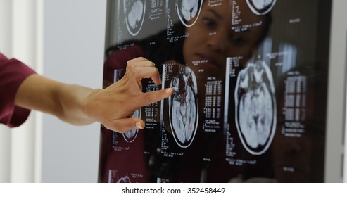 Doctors reviewing brain x-rays - Powered by Shutterstock