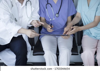 Doctors Reviewing Medical Chart In Hospital