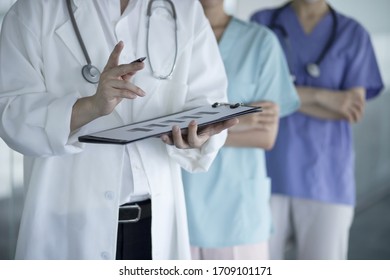 Doctors Reviewing Medical Chart In Hospital