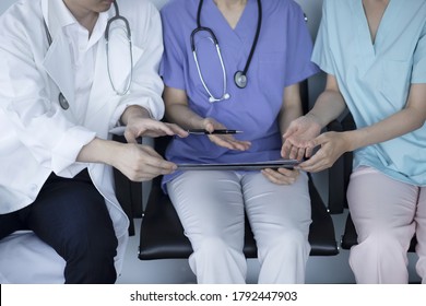 Doctors Reviewing Medical Chart In Hospital