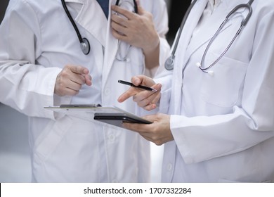 Doctors Reviewing Medical Charts In Meeting