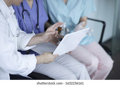 Doctors Reviewing Medical Data With Laptop