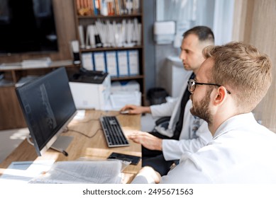 Doctors Reviewing Medical Images. Two doctors in a medical office, reviewing medical images on a computer screen. - Powered by Shutterstock