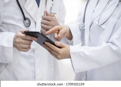 Doctors reviewing medical records with digital tablet