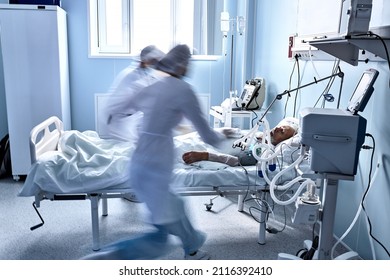 doctors run around the ward trying to help dying patient, lying on bed in hospital, save the life of sick senior man. at day time or in morning. in modern clinic or hospital. treatment, medicine