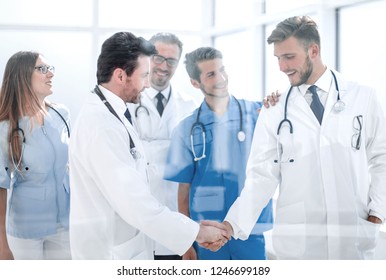 doctors shaking hands in hospital corridor - Powered by Shutterstock