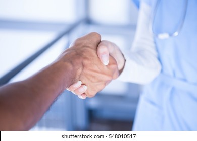 Doctors shaking hands in hospital corridor - Powered by Shutterstock