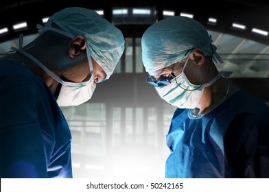 Doctors Team In Surgery In A Dark Background