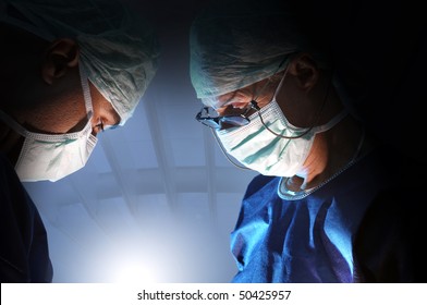 Doctors Team In Surgery In A Dark Background