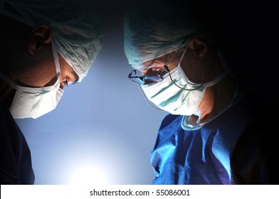 Doctors team in surgery in a dark background