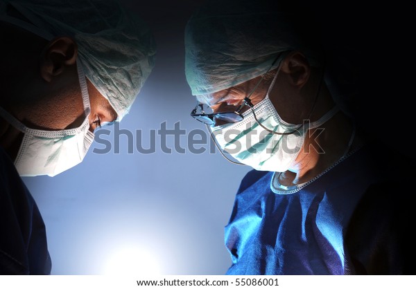 Doctors team in\
surgery in a dark\
background