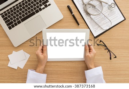 Doctors use tablet computer to search for patient data. view from above. Free space on tablet screen for your text.