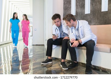 Doctors using cell phones in the hospital corridor. Medical concept - Powered by Shutterstock