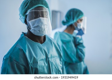 Doctors at work inside hospital during coronavirus outbreak - Focus on african man face - Shutterstock ID 1931949419