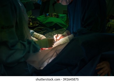 Doctors Working On The Wound Of A Mother That Just Gave Child Birth Via A Caesarean Section.