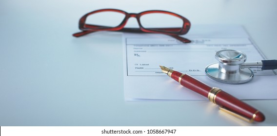 Doctor's Workspace Working Table With Patient's Discharge Blank Paper Form, Medical Prescription, Stethoscope On Desk