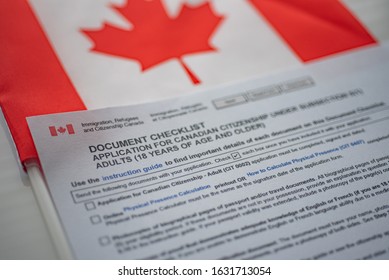 Document Check List Application For Canadian Citizenship Next To Canadian Flag, Close Up View. 