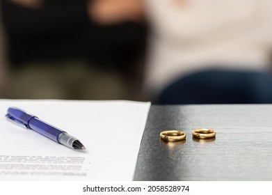 Document Of A Decree Of Divorce, Dissolution, Annulment Of The Marriage Along With Some Wedding Rings. Documents Of Legal Separation, Presentation Of Divorce Papers Or Prenuptial Agreement.