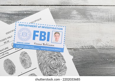 Document Of FBI Agent And Paper Sheets With Finger Prints On Wooden Background