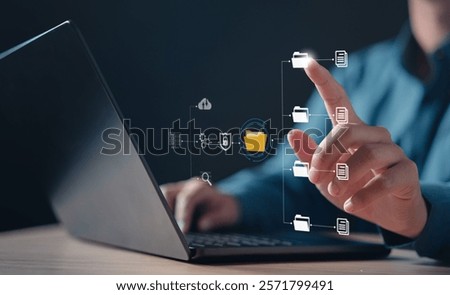document, file, folder, management, report, information, finance, financial, insurance, search. A person is using a laptop with a file icon on the screen. The person is touching the icon with finger.